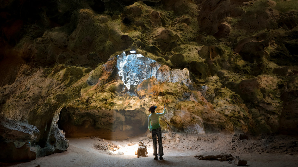 visitor exploring caves, an unique things to do in Aruba